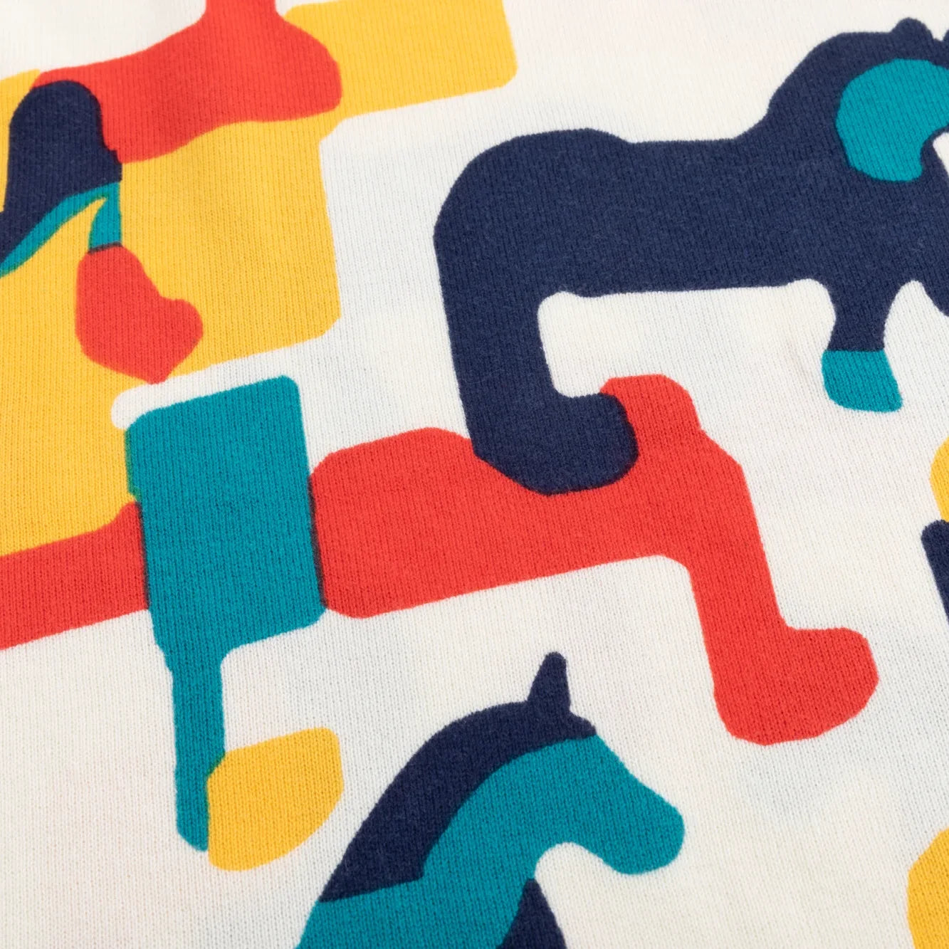 Close-up of the abstract multicolour horse print on the ivory jumper.