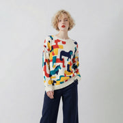 Model wearing an ivory organic cotton jumper with an abstract horse print, distressed ribbed trims and a regular dropped-shoulder fit.