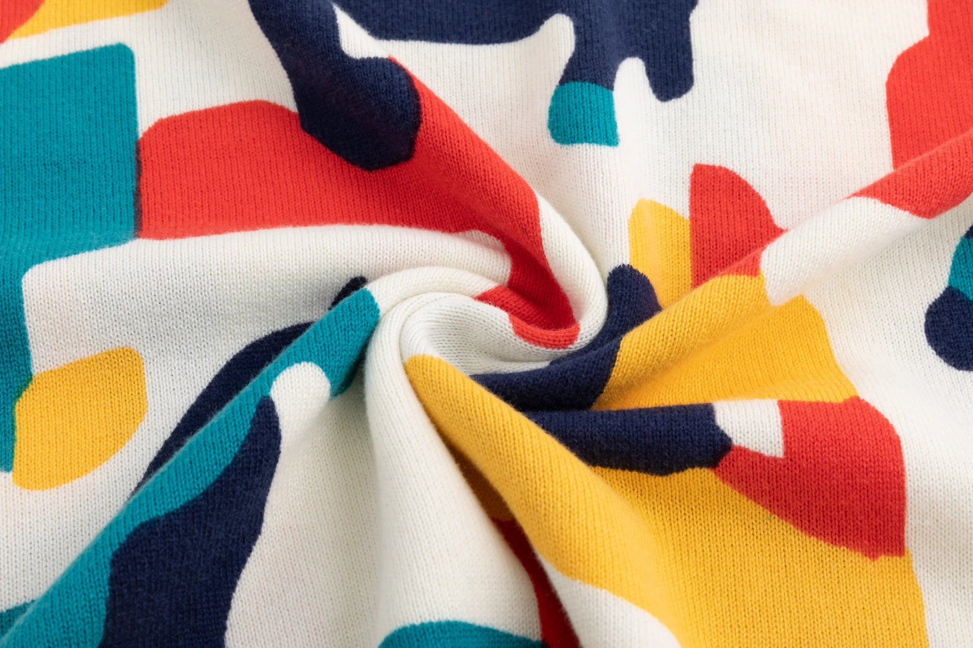 Close-up of the lightweight organic cotton knit texture and abstract horse print on the ivory jumper.