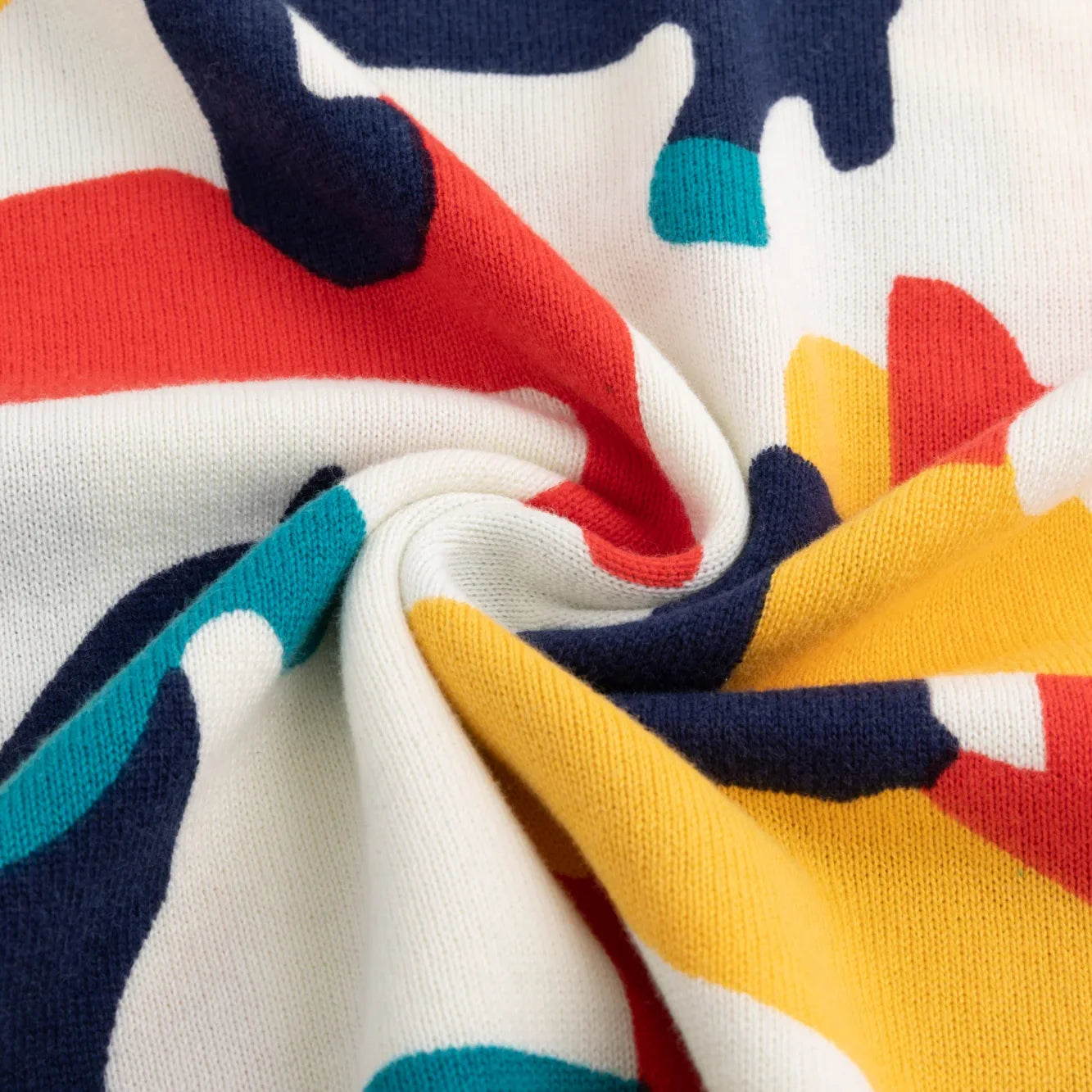 Close-up of the organic cotton knit texture and abstract horse print.
