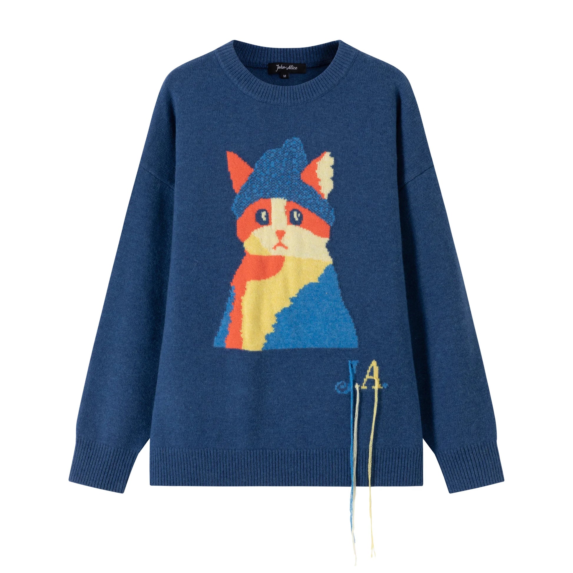 Front flat view of a blue merino wool jumper with an artistic cat intarsia on the front and JA lettering with tassel detail.