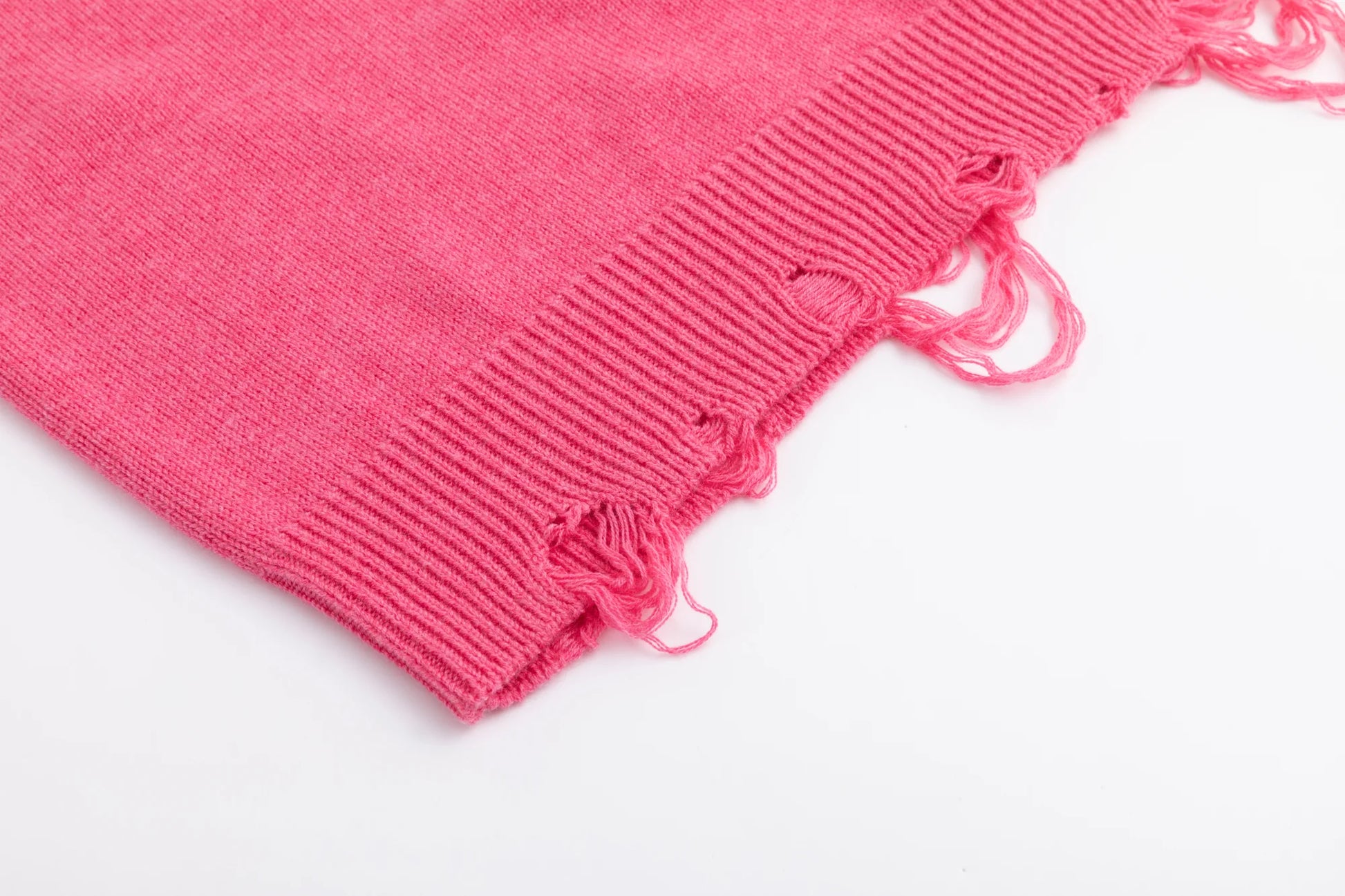Close-up of the distressed ribbed hem on the pink jumper.