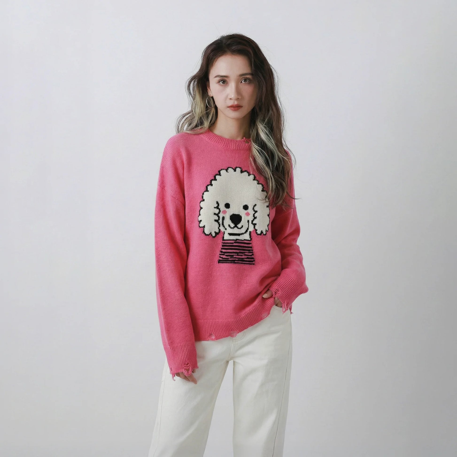 Model wearing a pink merino wool jumper with a teddy dog jacquard on the front and distressed ribbed trims.