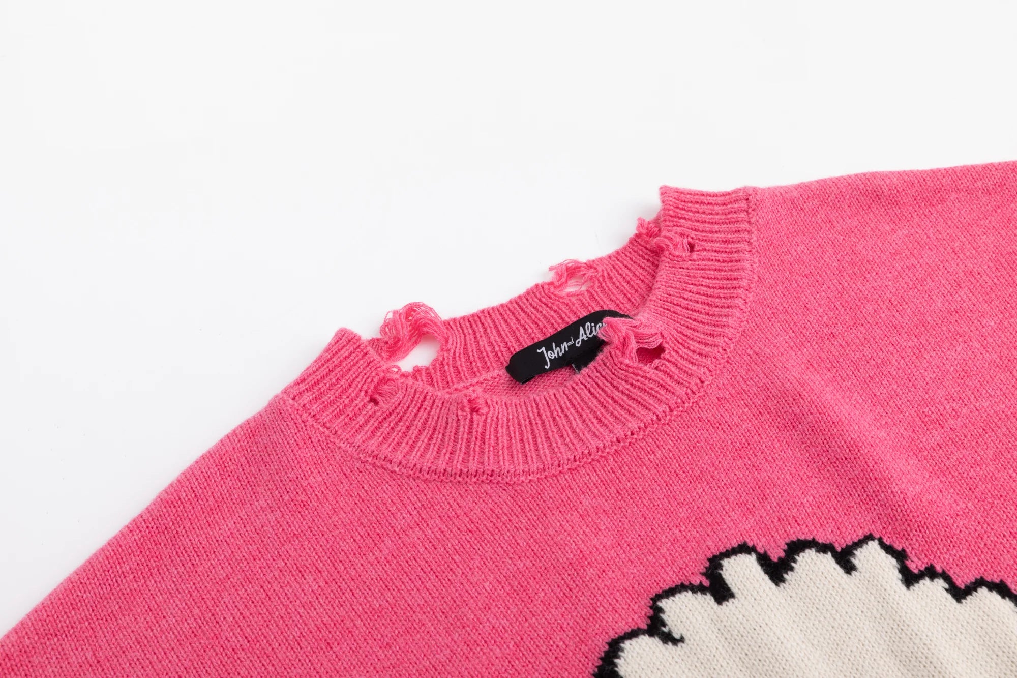 Close-up of the distressed ribbed neckline on the pink jumper with part of the front jacquard visible.